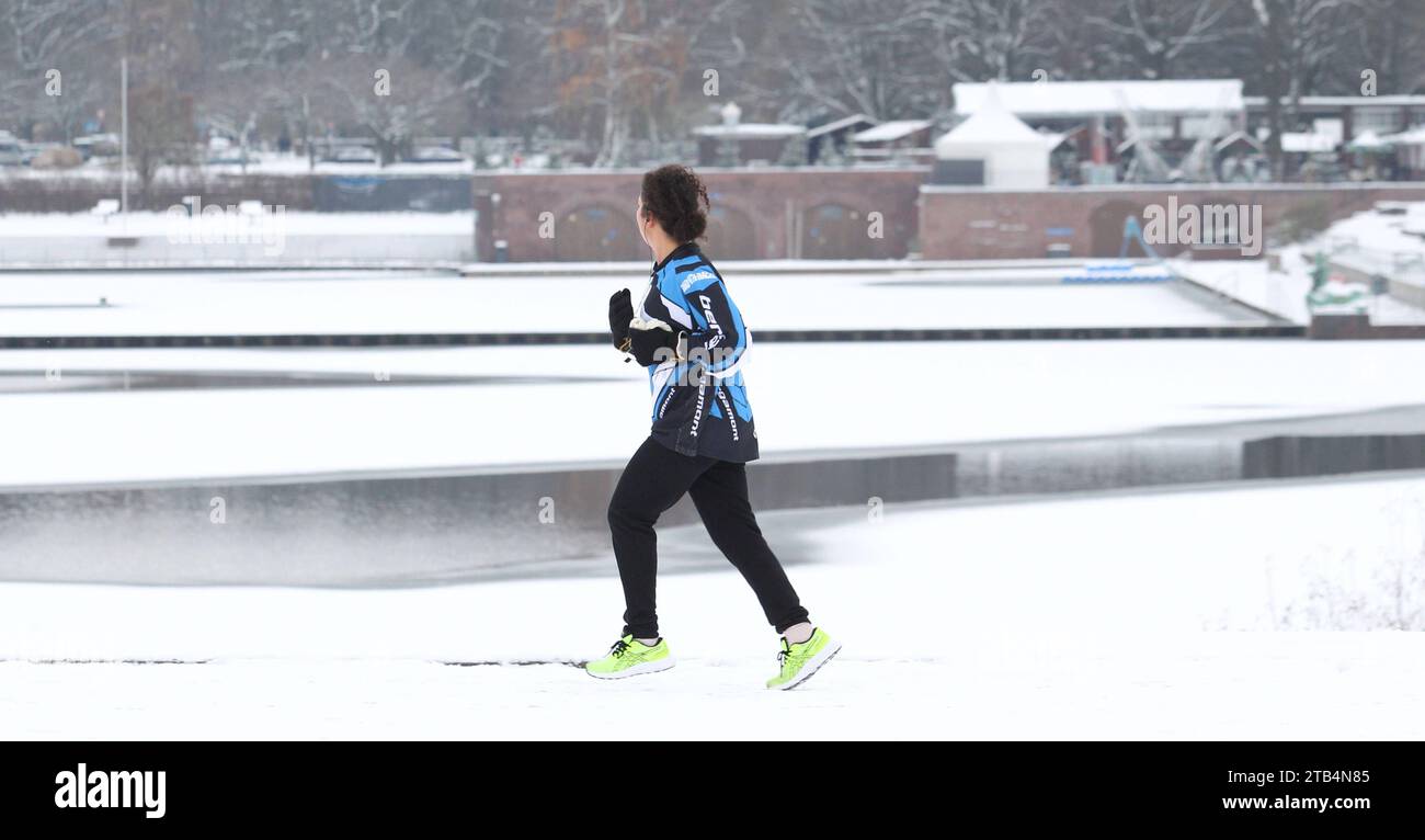 Eine Frau läuft auf einem mit Schnee bedecktem Weg am Stadtparksee vorbei. Winterhude Hamburg *** Une femme marche sur un chemin enneigé devant le Stadtparksee Winterhude Hamburg crédit : Imago/Alamy Live News Banque D'Images