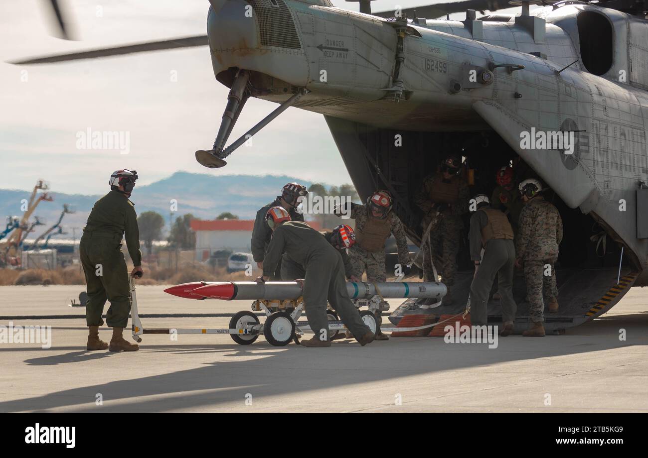 Les Marines américains avec la 3rd Marine Aircraft Wing All Type Model Series Armament Team déchargent les munitions d'un hélicoptère CH-53E Super Stallion avec le Marine Heavy Helicopter Squadron (HMH) 361, Marine Aircraft Group 16, 3rd MAW, lors d'un ravitaillement de nœud en soutien à l'exercice Steel Knight 23,2 à l'aérodrome d'Inyokern, Californie, le 2 décembre 2023. le réapprovisionnement a fourni du matériel à un point d’armement et de ravitaillement en carburant avancé pour que les aéronefs soient prêts à réagir et pour étendre leur portée de combat. Steel Knight 23,2 est un exercice en trois phases conçu pour former I Marine Expeditionary Force dans la planification, le déploiement et la com Banque D'Images