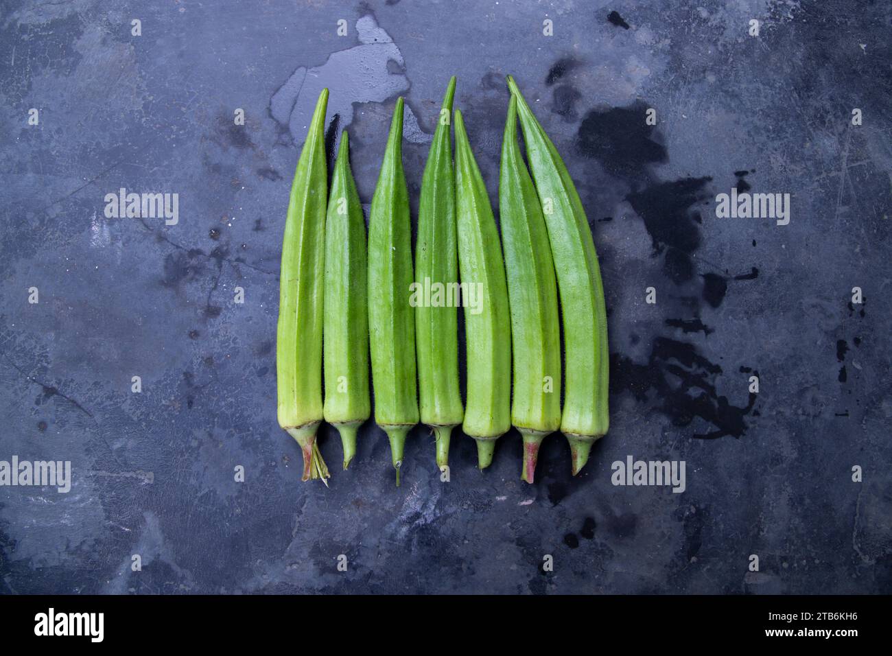 Légumes bio frais Lady's Finger ou Okra sur le sol en béton foncé Banque D'Images