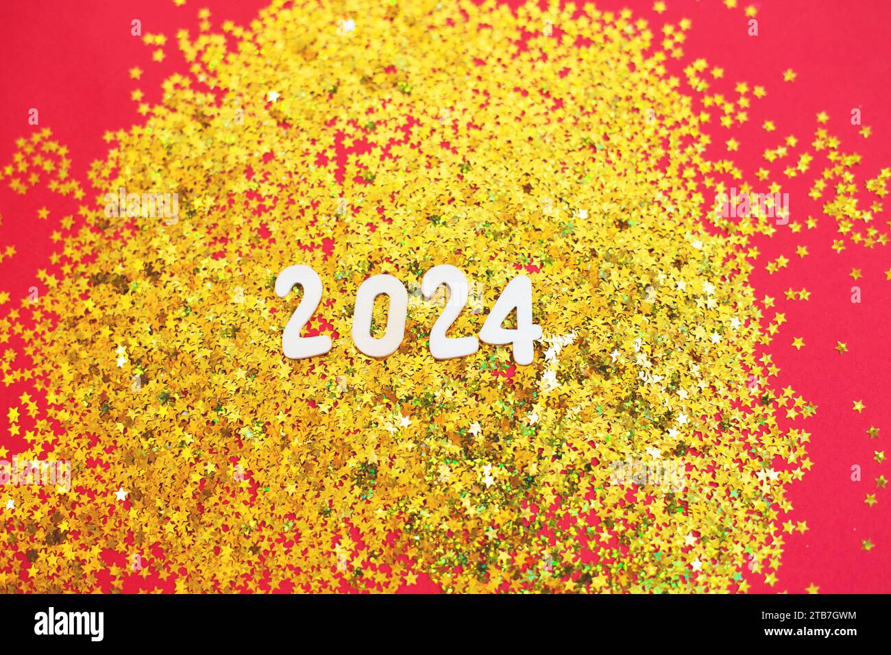 numéro en bois 2024 sur fond doré brillant de noël avec des confettis dorés festifs étincelants 