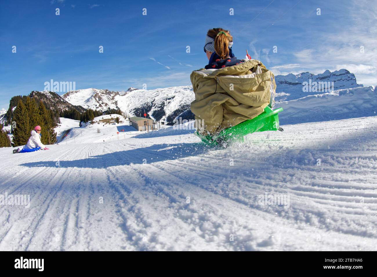 Flaine, station de ski dans les Alpes françaises (centre-est de la France) : les enfants descendent en luge sur une pente du domaine skiable, en hiver Banque D'Images