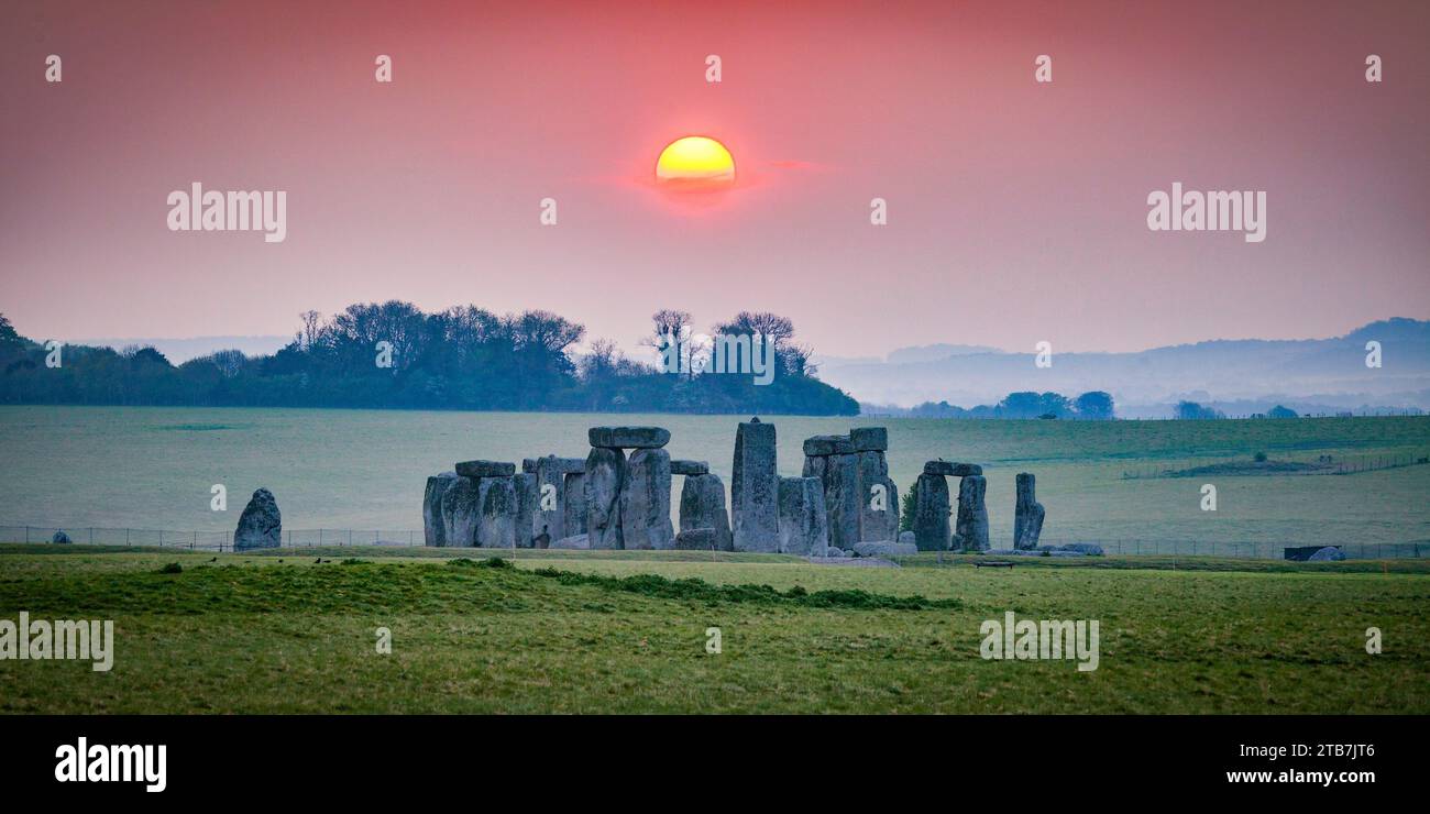 Le Soleil se levant sur les pierres à Stonehenge. Photo prise à l'extérieur du parc. Banque D'Images