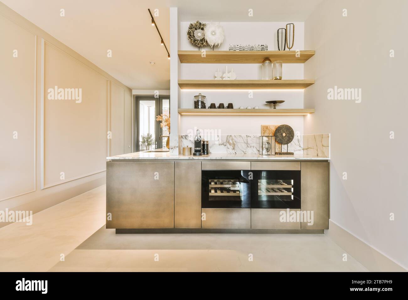 Intérieur d'une cuisine élégante avec des appareils et de la vaisselle avec des décors sur des étagères en bois dans un appartement moderne blanc Banque D'Images