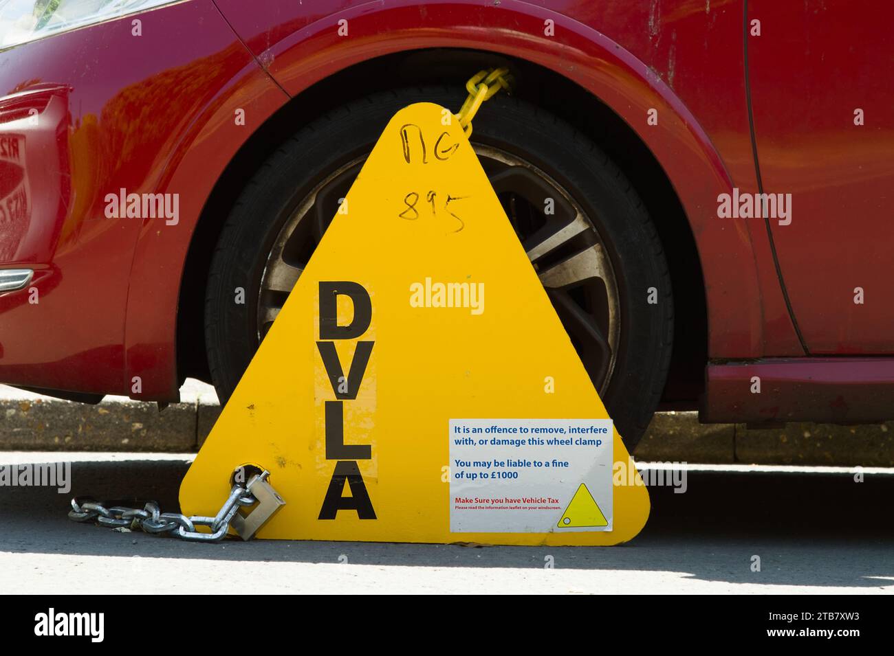 Pince de roue triangulaire DVLA attachée à Une voiture automobile avec avertissement de ne pas enlever, Angleterre Royaume-Uni Banque D'Images
