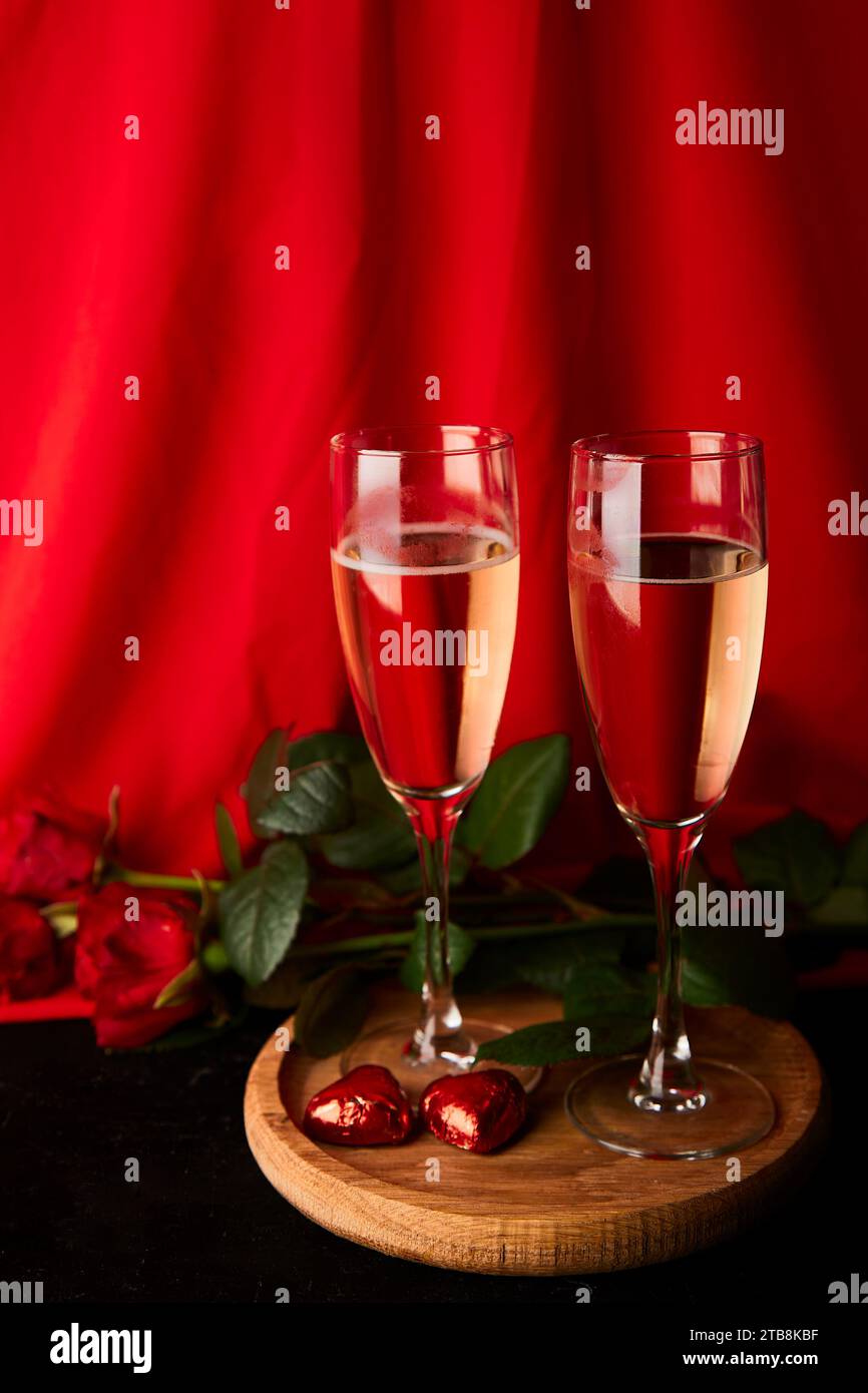 Fond de Saint Valentin esthétique avec des verres de champagne, des roses rouges, des bonbons. Espace de copie. Banque D'Images