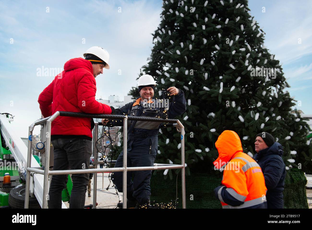 2023-12-05 Kiev, Ukraine. Travailleurs souriants décorant l'arbre de Noël donné à la ville par des patrones. Banque D'Images
