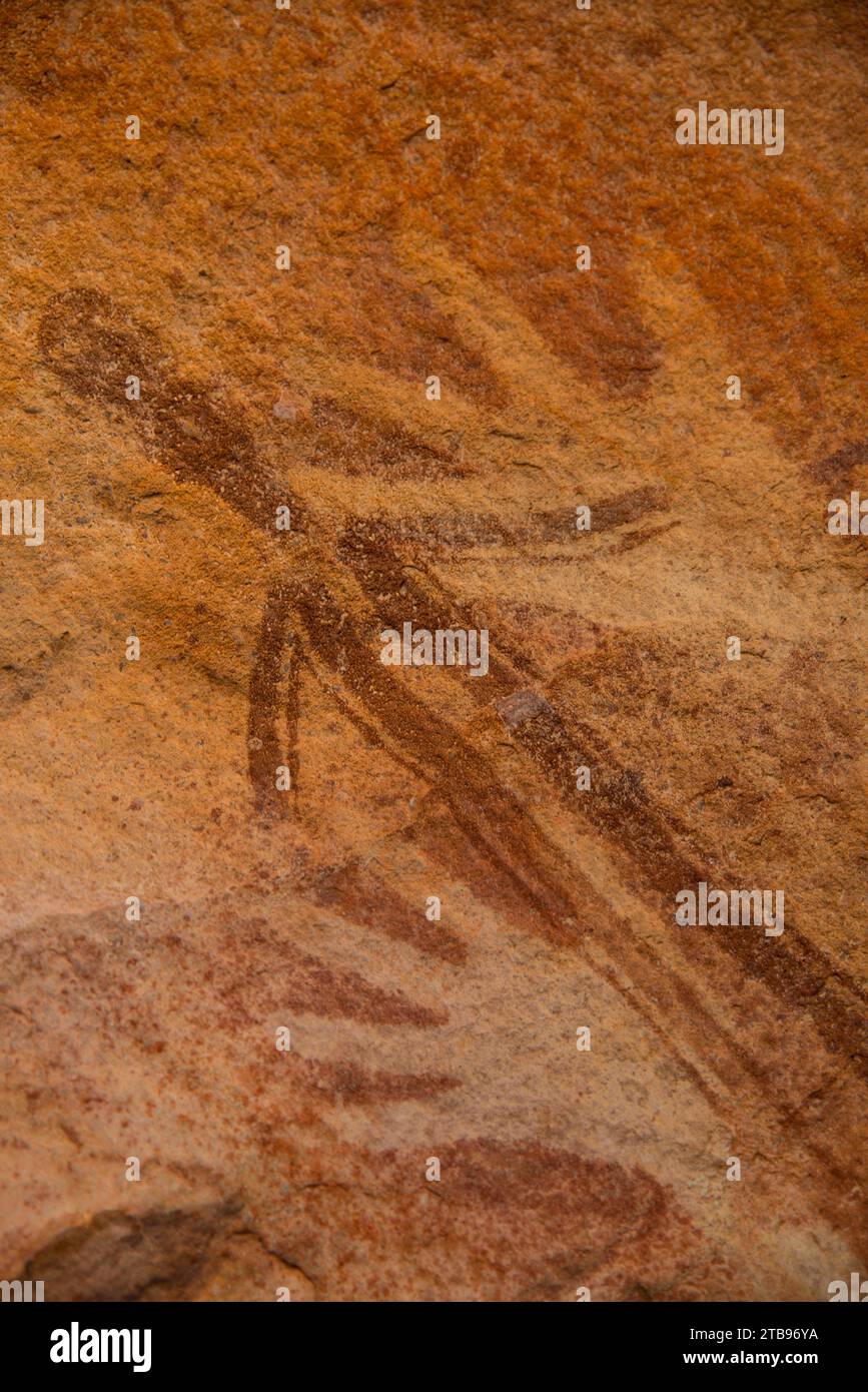 Figure humaine stylisée superposée à deux images au pochoir de la main droite, faisant partie de la collection Bradshaw Rock Paintings d'art préhistorique australien Banque D'Images