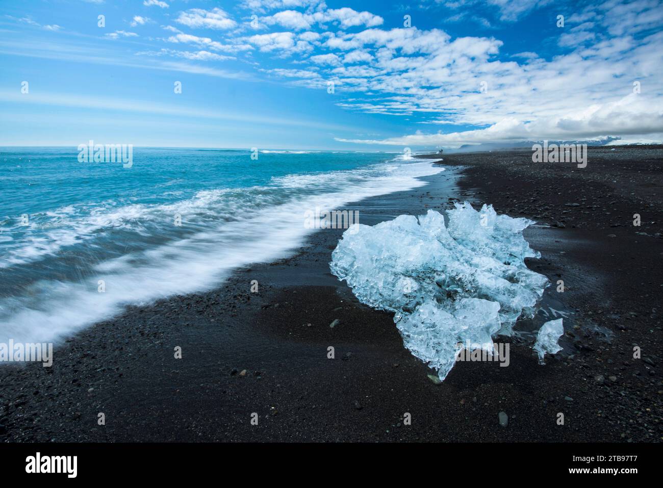 Petit iceberg de Vatnajokull sur la rive d'une plage de sable noir ; Islande Banque D'Images