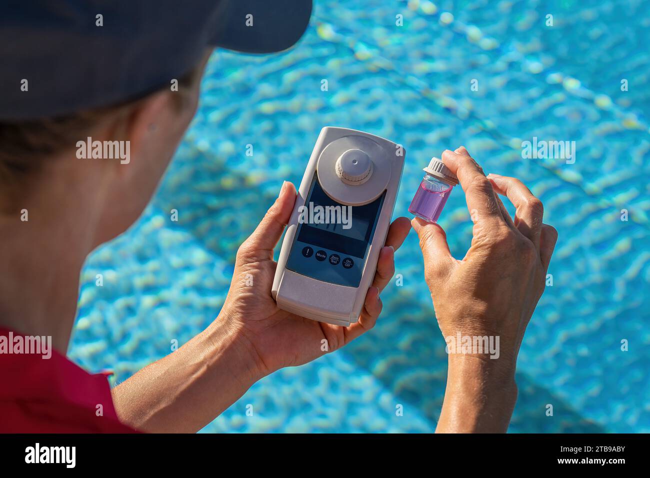 Gros plan d'un technicien de piscine vérifiant le niveau de pH de l'eau avec un compteur numérique Banque D'Images