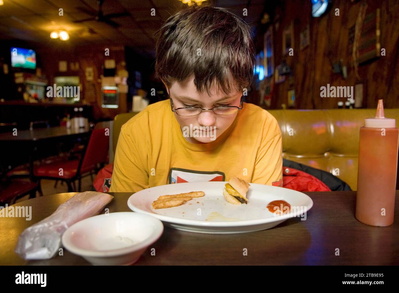 Garçon finissant son déjeuner dans un restaurant ; Anselmo, Nebraska, États-Unis d'Amérique Banque D'Images