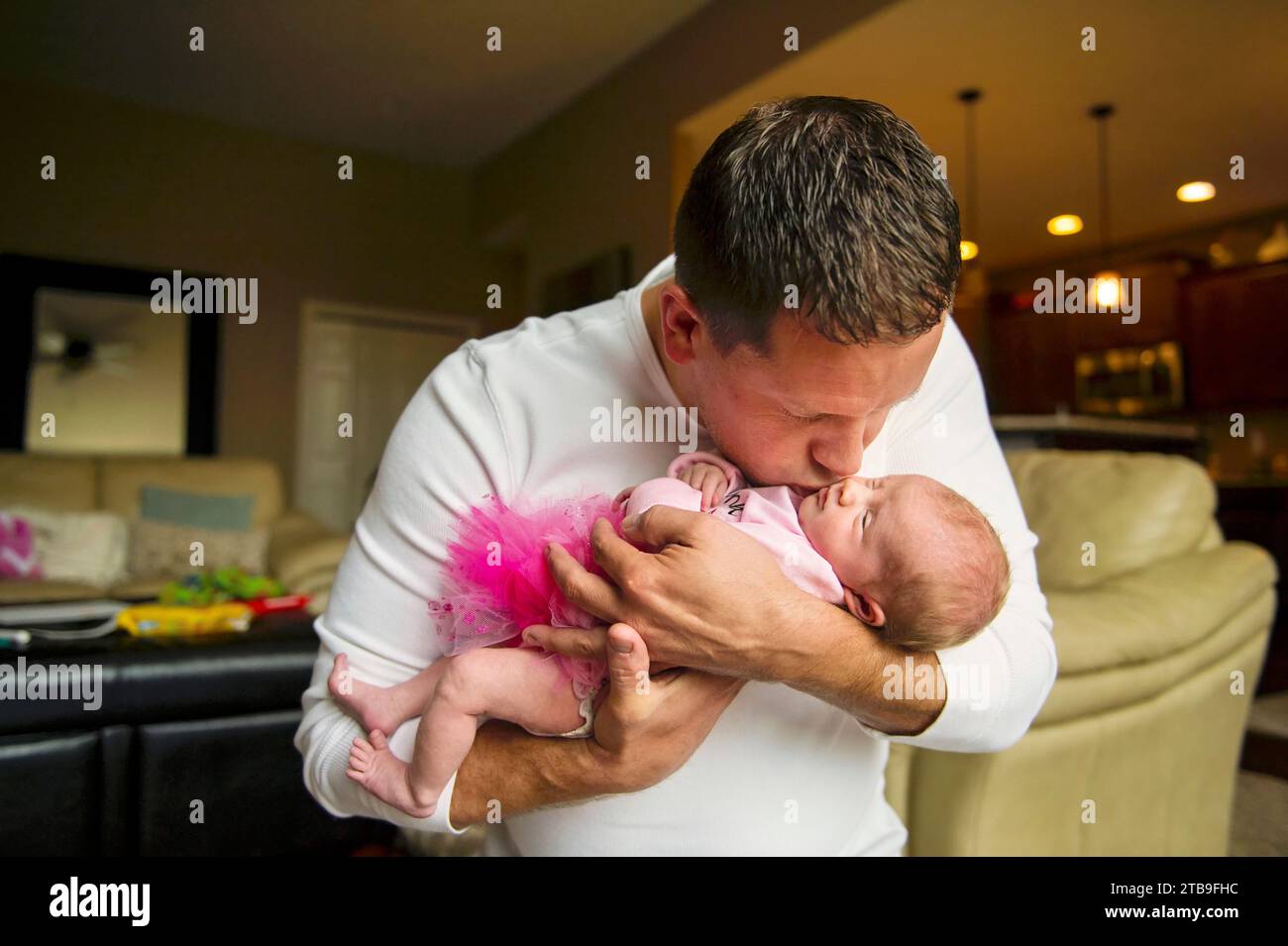 Père tient et embrasse sa fille nouvelle-née ; Lincoln, Nebraska, États-Unis d'Amérique Banque D'Images