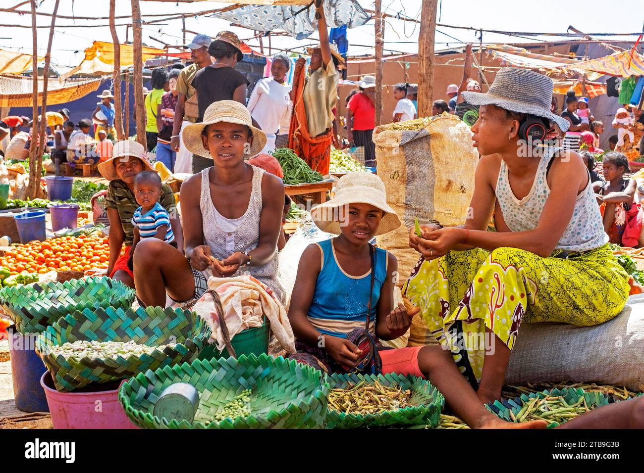 Filles et enfants malgaches vendant des fruits et légumes au marché alimentaire dans la ville Ambalavao, haute Matsiatra, Hautes terres centrales, Madagascar, Afrique Banque D'Images