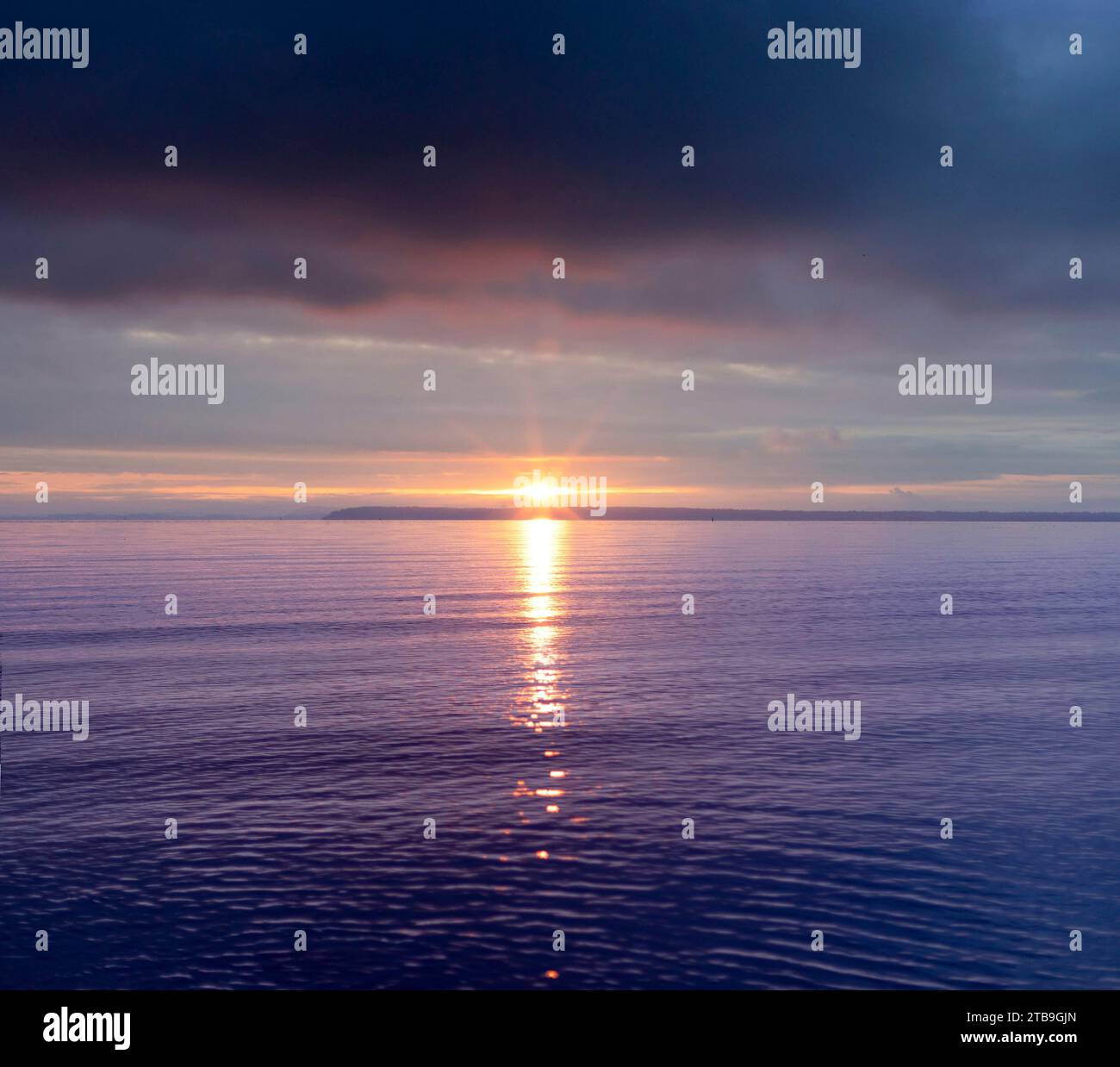 Vue imprenable sur l'océan Pacifique au crépuscule avec la lueur du soleil sur l'eau de couleur mauve ; Crescent Beach, Surrey, Colombie-Britannique, Canada Banque D'Images