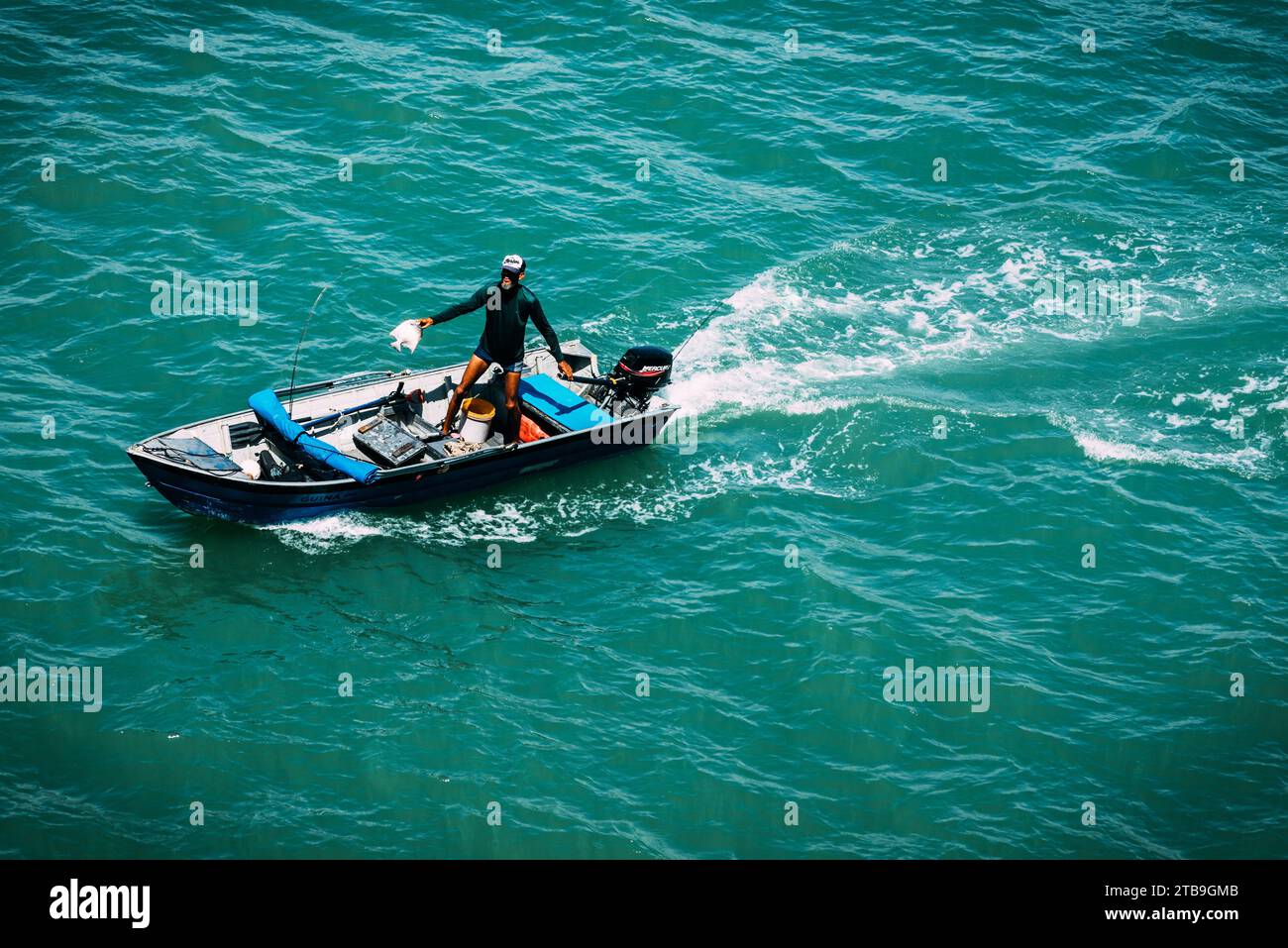 Vue en haute perspective d'un pêcheur souriant montrant sa prise à Ilheus, Brésil Banque D'Images