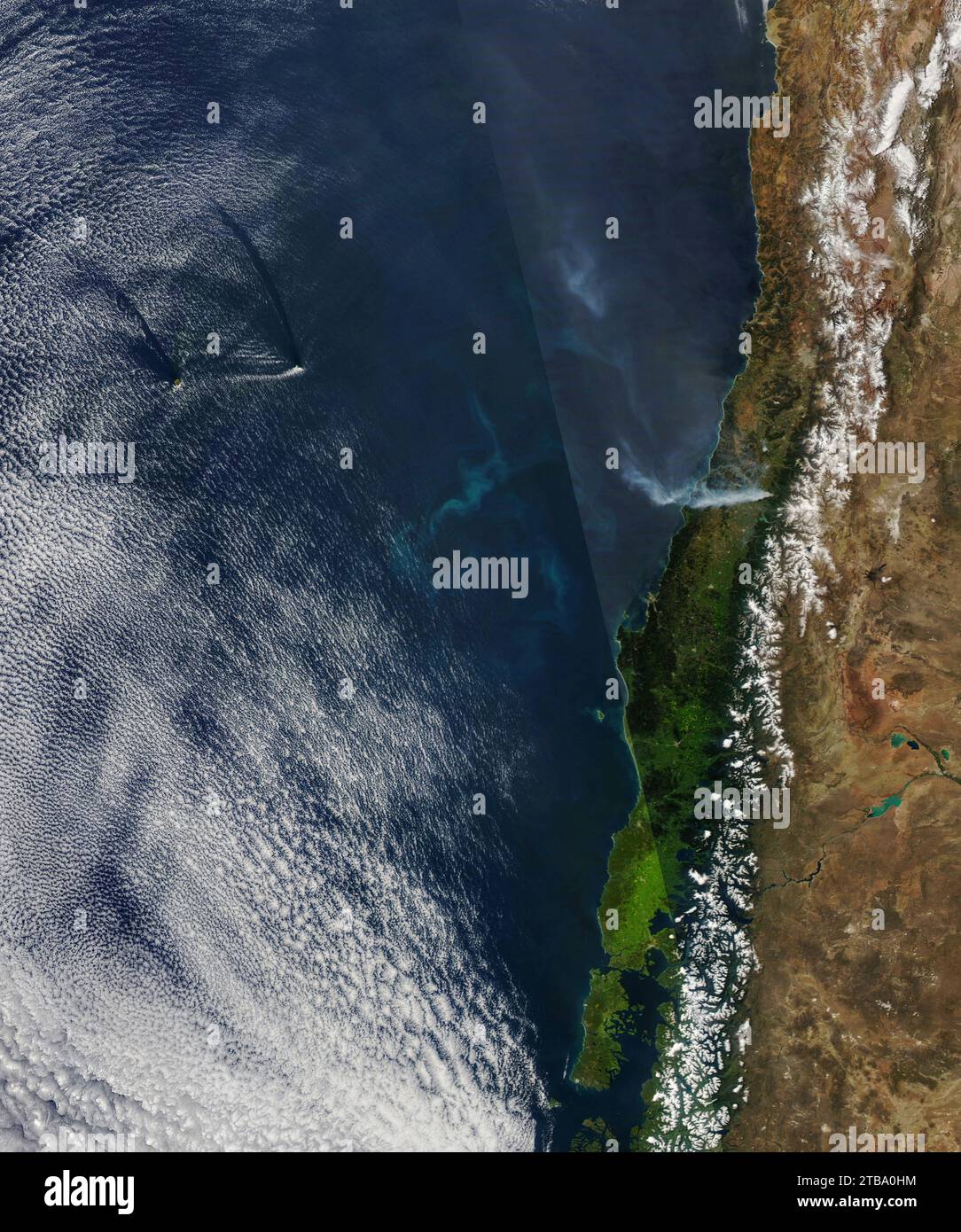 Vue satellite de fumée, de sillage de nuages et d'une floraison de phytoplancton au large des côtes du centre du Chili. Banque D'Images