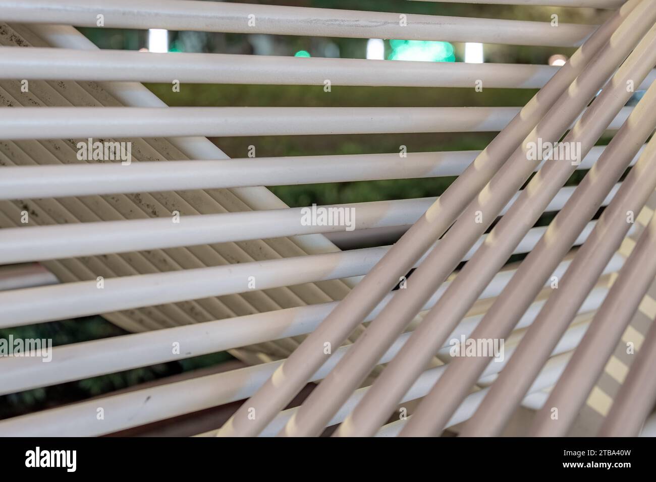 Photo de closeup de nuit de banc de parc de structure de tube blanc dans un environnement urbain de ville. Banque D'Images