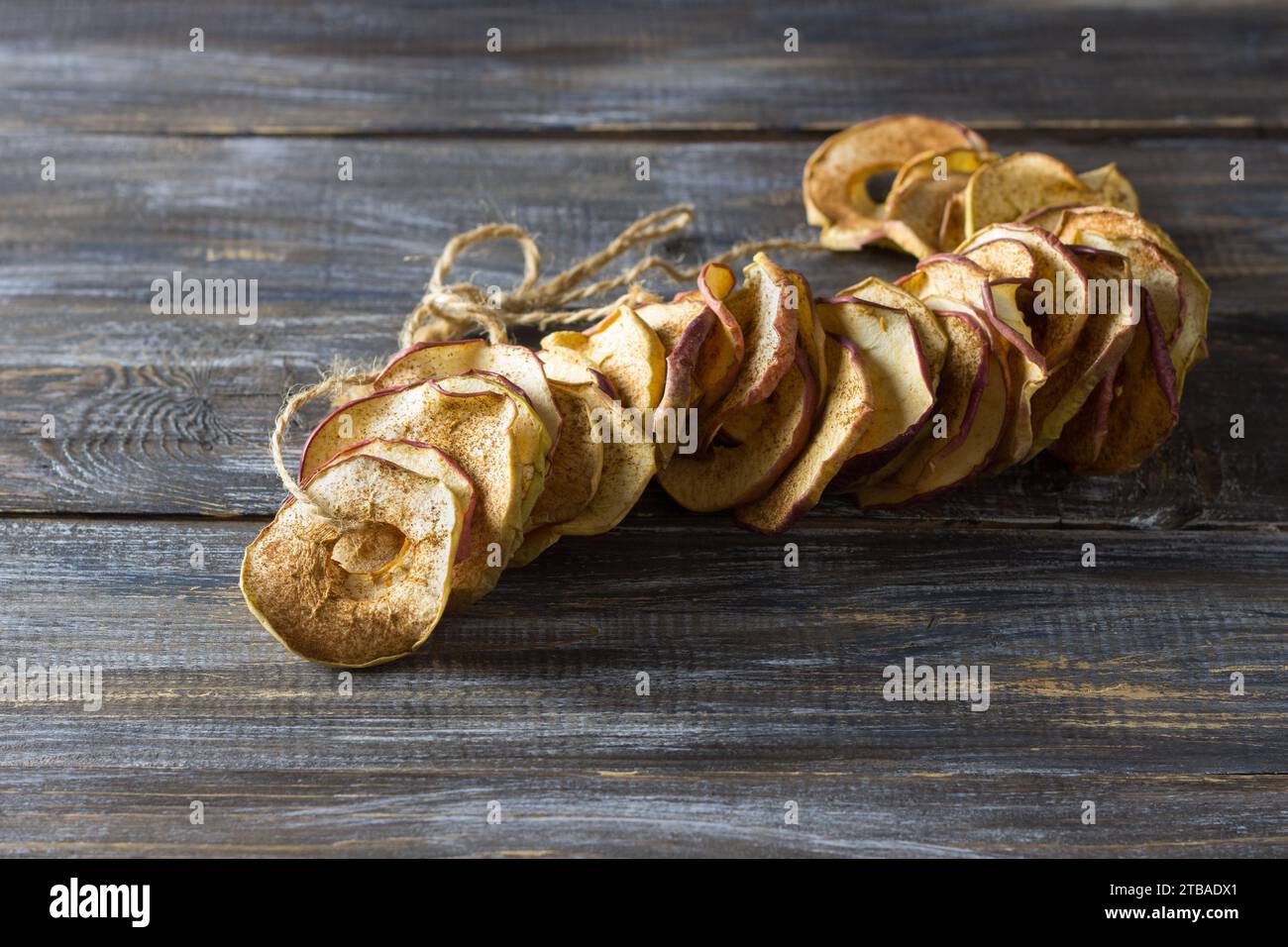 Pommes séchées maison à la cannelle, chips de pomme sur fond en bois. Délicieux en-cas sain Banque D'Images