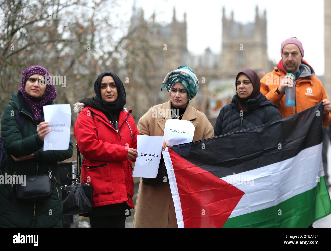 Londres, Royaume-Uni. 05 décembre 2023. Des manifestants brandissent les noms de certains des professionnels de la santé tués à Gaza tandis qu'un autre brandit un drapeau palestinien lors d'une manifestation devant l'hôpital St Thomas. Les travailleurs de la santé se rassemblent devant leur hôpital, St Thomas, pour souligner et se souvenir des collègues morts ou portés disparus à Gaza pendant la guerre. Ils réclament un cessez-le-feu permanent. Crédit : SOPA Images Limited/Alamy Live News Banque D'Images