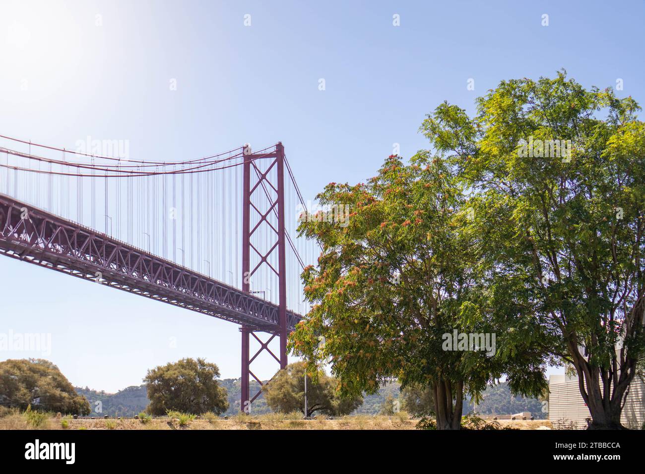 Vue de jour de l'emblématique pont 25 de Abril de Lisbonne : un paysage horizontal pris depuis le niveau du sol, capturant le majestueux pont suspendu rouge Banque D'Images