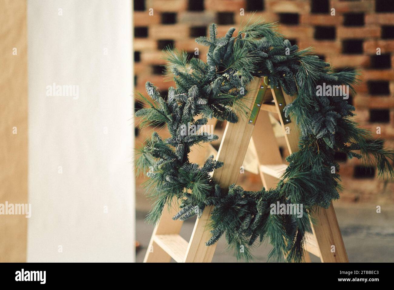 Une couronne de Noël festive disposée pour créer une forme circulaire devant un mur de briques Banque D'Images