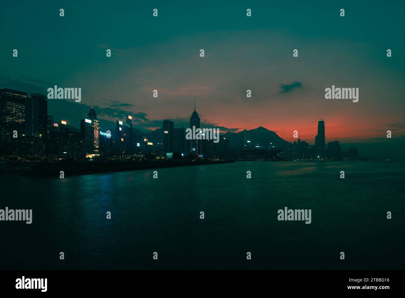 Ciel rose et orange au-dessus de l'île de Hong Kong avec mer lisse de longue exposition. Banque D'Images