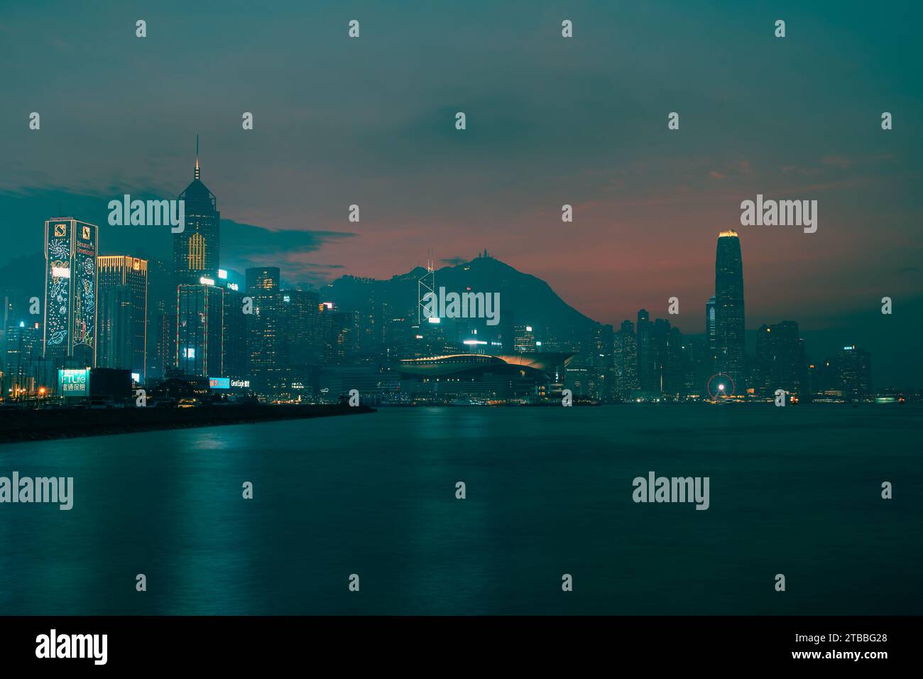 Ciel rose et orange au-dessus de l'île de Hong Kong avec mer lisse de longue exposition. Banque D'Images