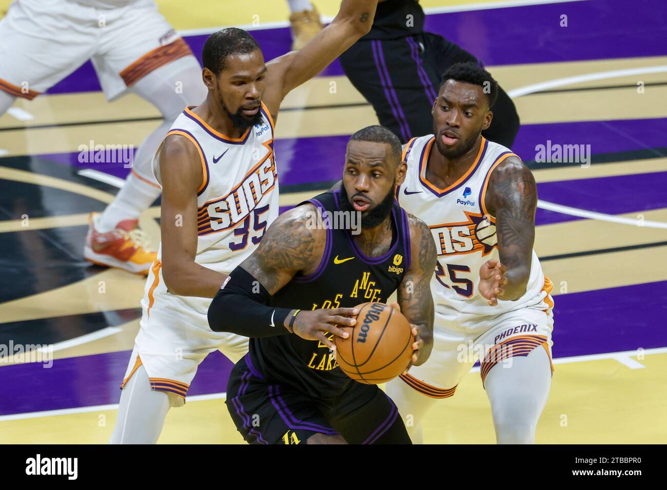Los Angeles, États-Unis. 5 décembre 2023. LeBron James (C) des Lakers de Los Angeles est défendu par Kevin durant (L) des Phoenix Suns et Nassir Little lors d'un match de basket-ball NBA à Los Angeles, aux États-Unis, le 5 décembre 2023. Crédit : Zhao Hanrong/Xinhua/Alamy Live News Banque D'Images