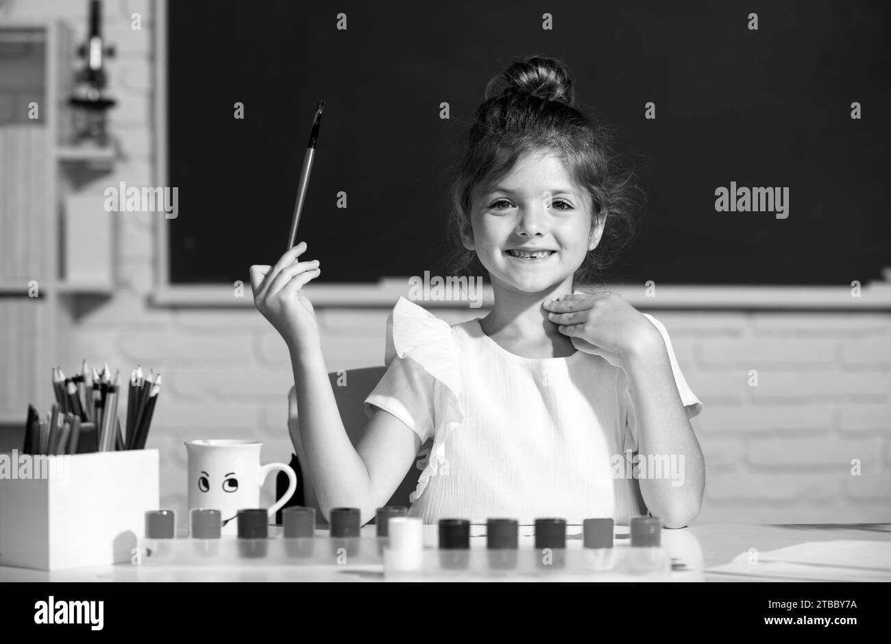 Jolie petite fille enfant peinture avec peinture couleur et pinceau. Croissance créative des enfants. Leçon de dessin à l'école Banque D'Images