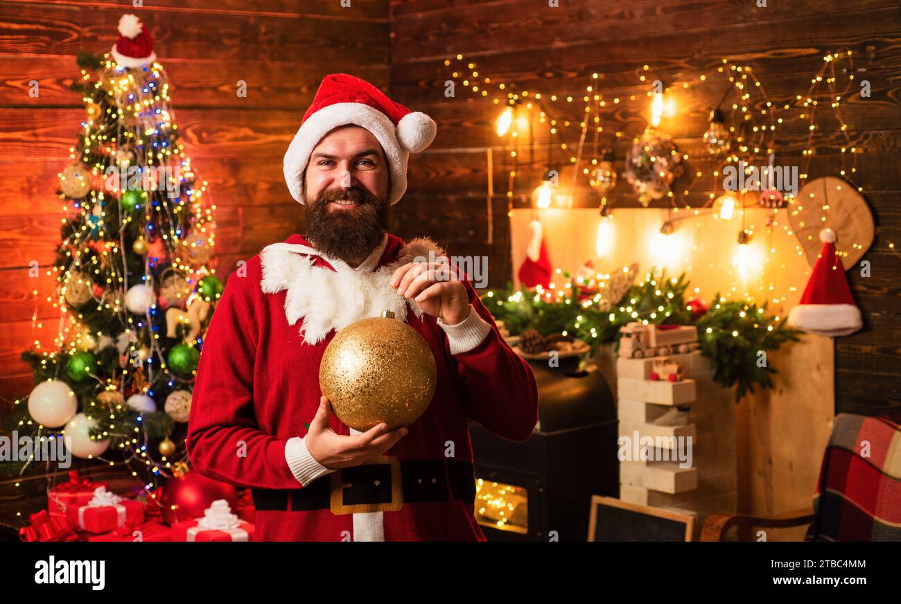 Homme hipster, père Noël barbu fêtent Thanksgiving et Noël. Ambiance de Noël à la maison. Portrait de mode de bel homme à l'intérieur avec Christma Banque D'Images