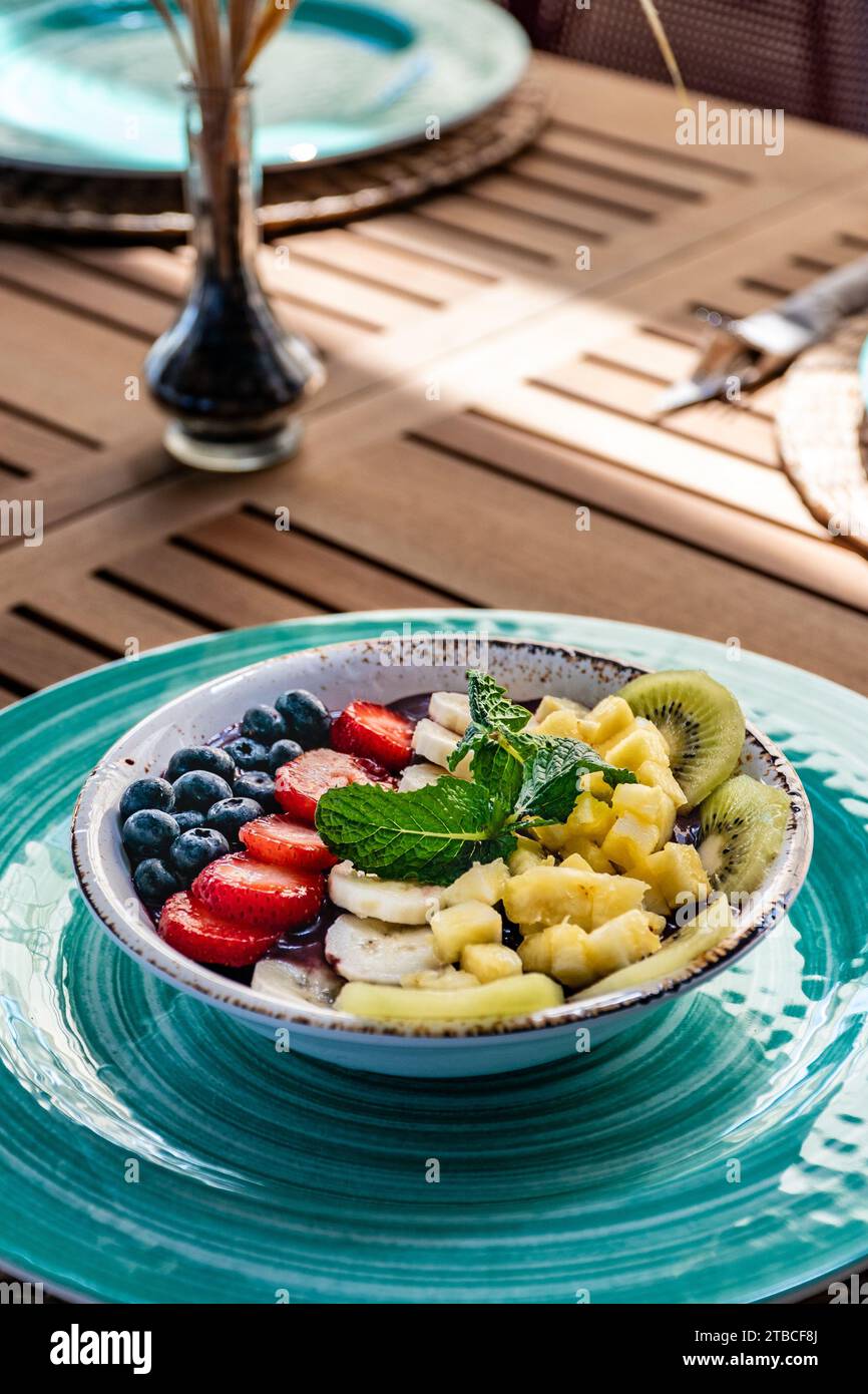 une image portrait d'un bol de crème glacée tropicale d'açai fraîche garnie de divers fruits. Banque D'Images