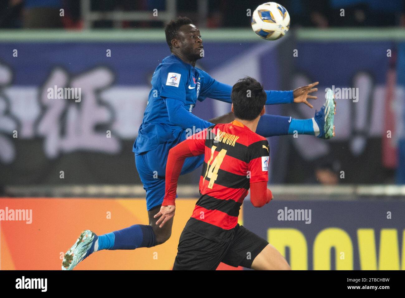 Wuhan, province chinoise du Hubei. 6 décembre 2023. Abdul-Aziz Yakubu (à gauche) du Wuhan Three Towns FC arrête le ballon lors du match de football de la ligue des champions de l'AFC entre le Wuhan Three Towns FC de Chine et le Pohang Steelers de Corée du Sud au Wuhan Sports Center Stadium à Wuhan, dans la province du Hubei en Chine centrale, le 6 décembre 2023. Crédit : Xiao Yijiu/Xinhua/Alamy Live News Banque D'Images