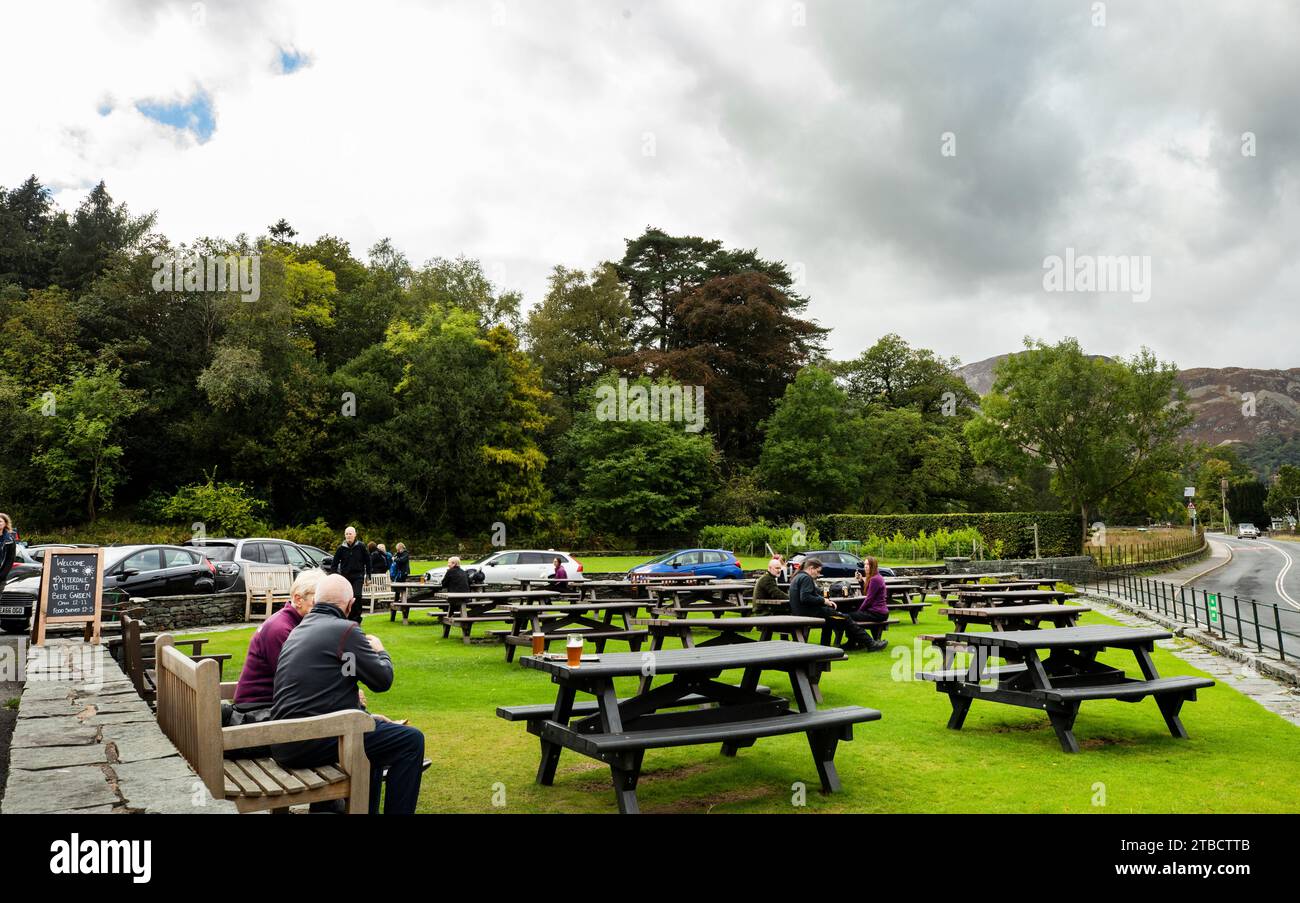 Les gens s'assoient à des tables de pique-nique dans le café en plein air à l'extérieur de l'hôtel Patterdale, Patterdale, Lake District, Cumbria Banque D'Images