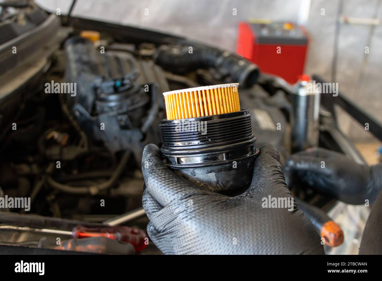 Remplacement du filtre à huile de voiture. Homme mécanicien tenant le filtre à huile de moteur de voiture dans sa main Banque D'Images