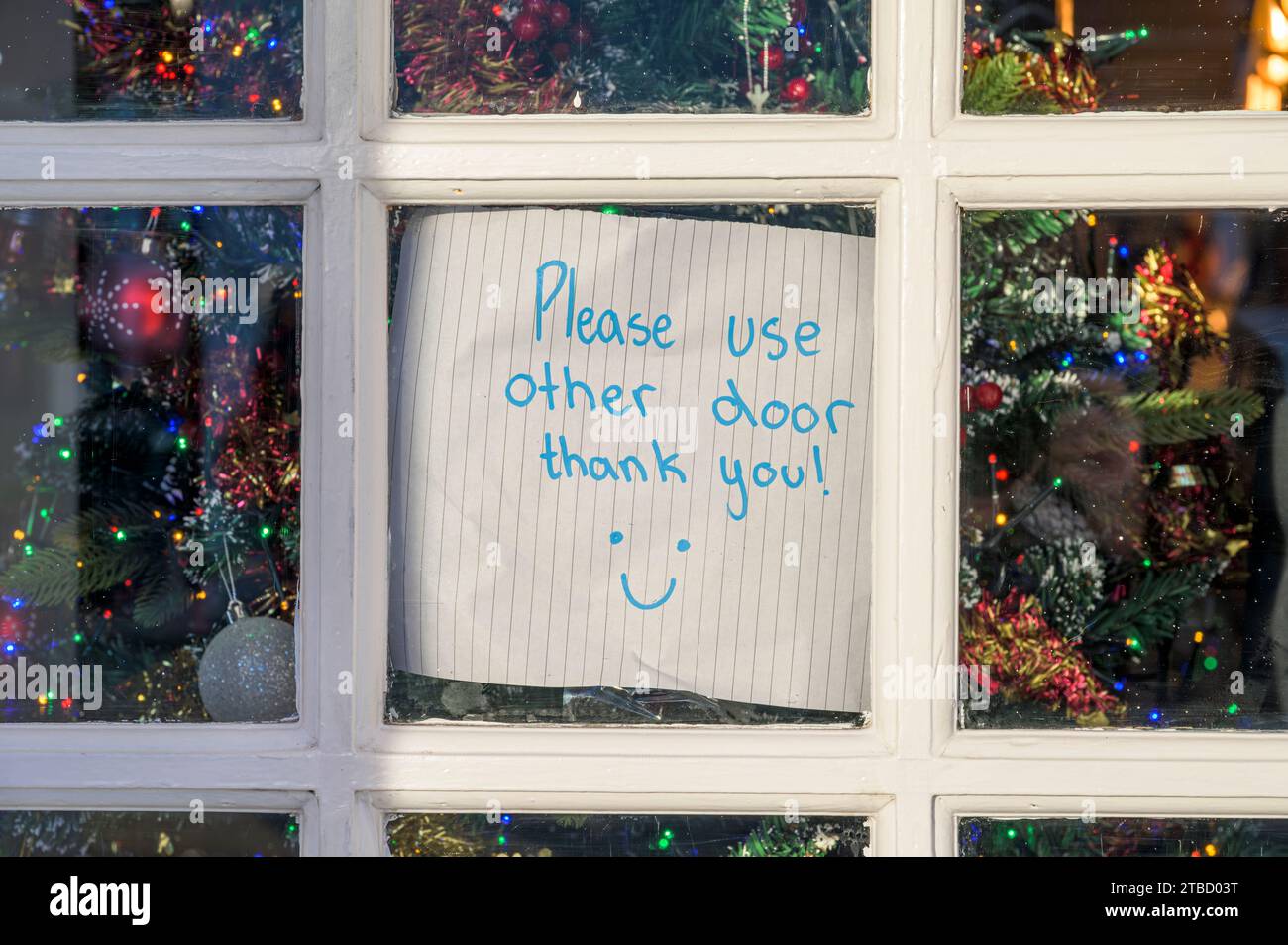Veuillez utiliser le signe de remerciement autre porte avec un visage souriant sur une porte fermée Banque D'Images