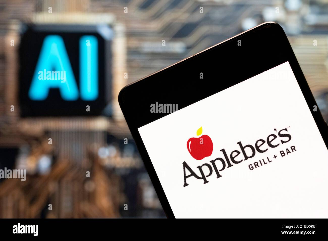Dans cette illustration photo, le logo de la chaîne américaine de restaurants sandwichs Applebee est affiché sur un smartphone avec une puce d'intelligence artificielle (IA) et un symbole en arrière-plan. Banque D'Images