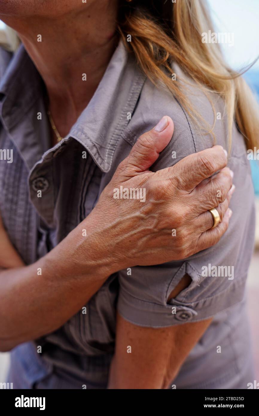 Femme méconnaissable touchant l'épaule causant de la douleur. Douleurs articulaires, arthrite et problèmes tendineux. Banque D'Images