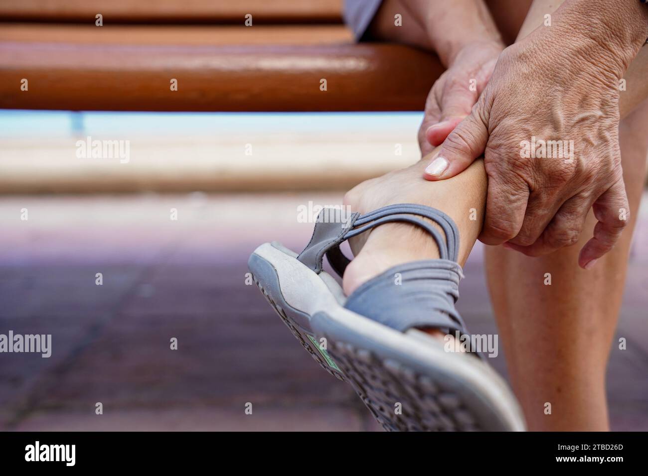 gros plan d'une entorse à la cheville ou d'une blessure musculaire assise à l'extérieur dans la banque Banque D'Images