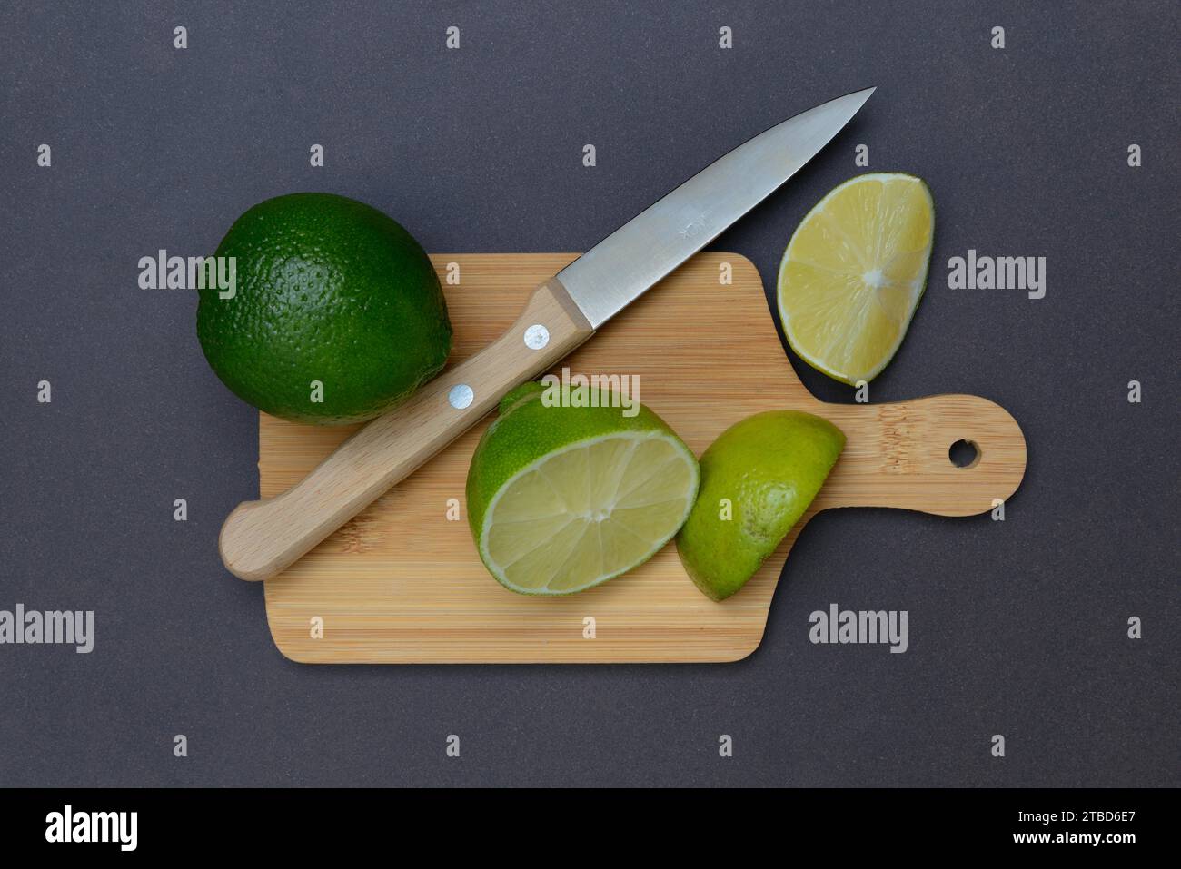 Chaux coupée en deux sur une planche à découper avec un couteau de cuisine Banque D'Images
