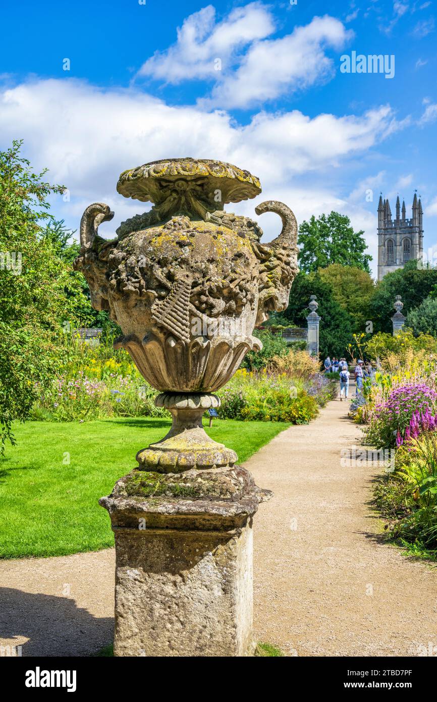 Urne en pierre ornée dans le jardin botanique d'Oxford, avec Magdalen Tower en arrière-plan dans le centre-ville d'Oxford, Oxfordshire, Angleterre, Royaume-Uni Banque D'Images