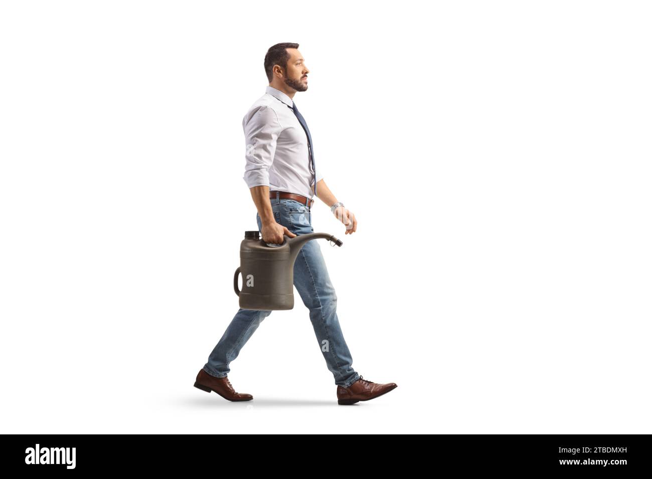 Photo de profil pleine longueur d'un homme d'affaires marchant avec un bidon d'essence isolé sur fond blanc Banque D'Images