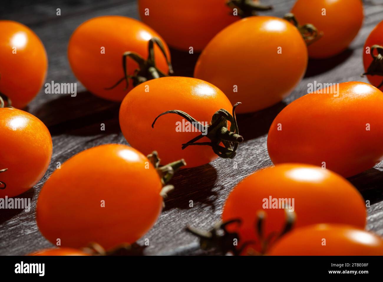 tomate cerise orange prune sur fond de bois Banque D'Images