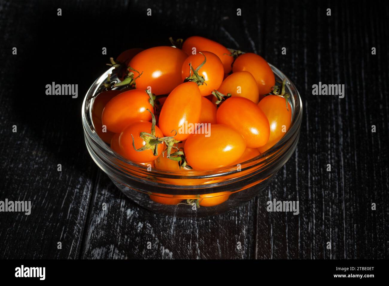 tomate cerise orange prune sur fond de bois Banque D'Images