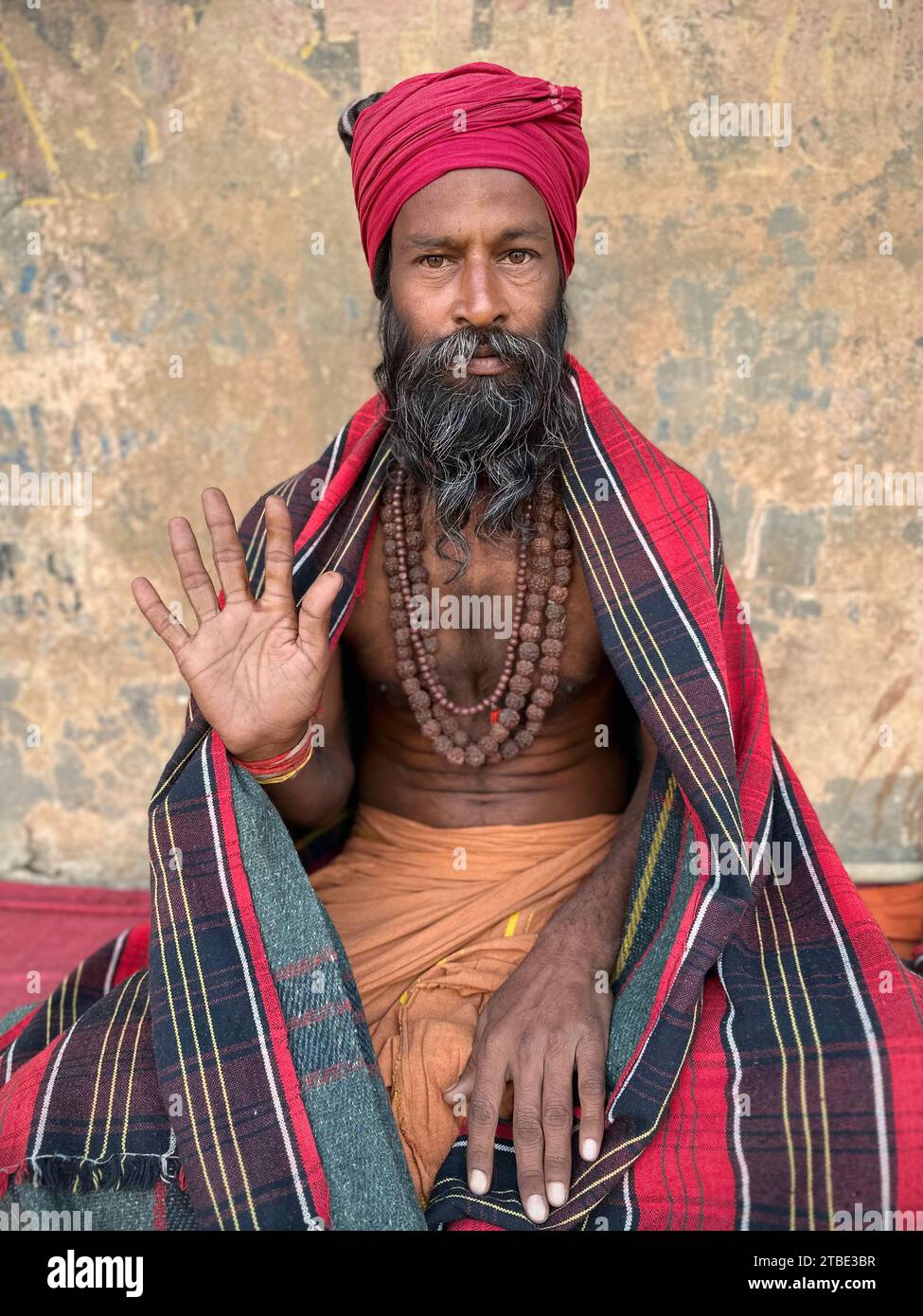 Portrait de trois quarts de long d'un Sadhu avec une main ouverte tenue vers le haut, Varanasi, Uttar Pradesh, Inde Banque D'Images