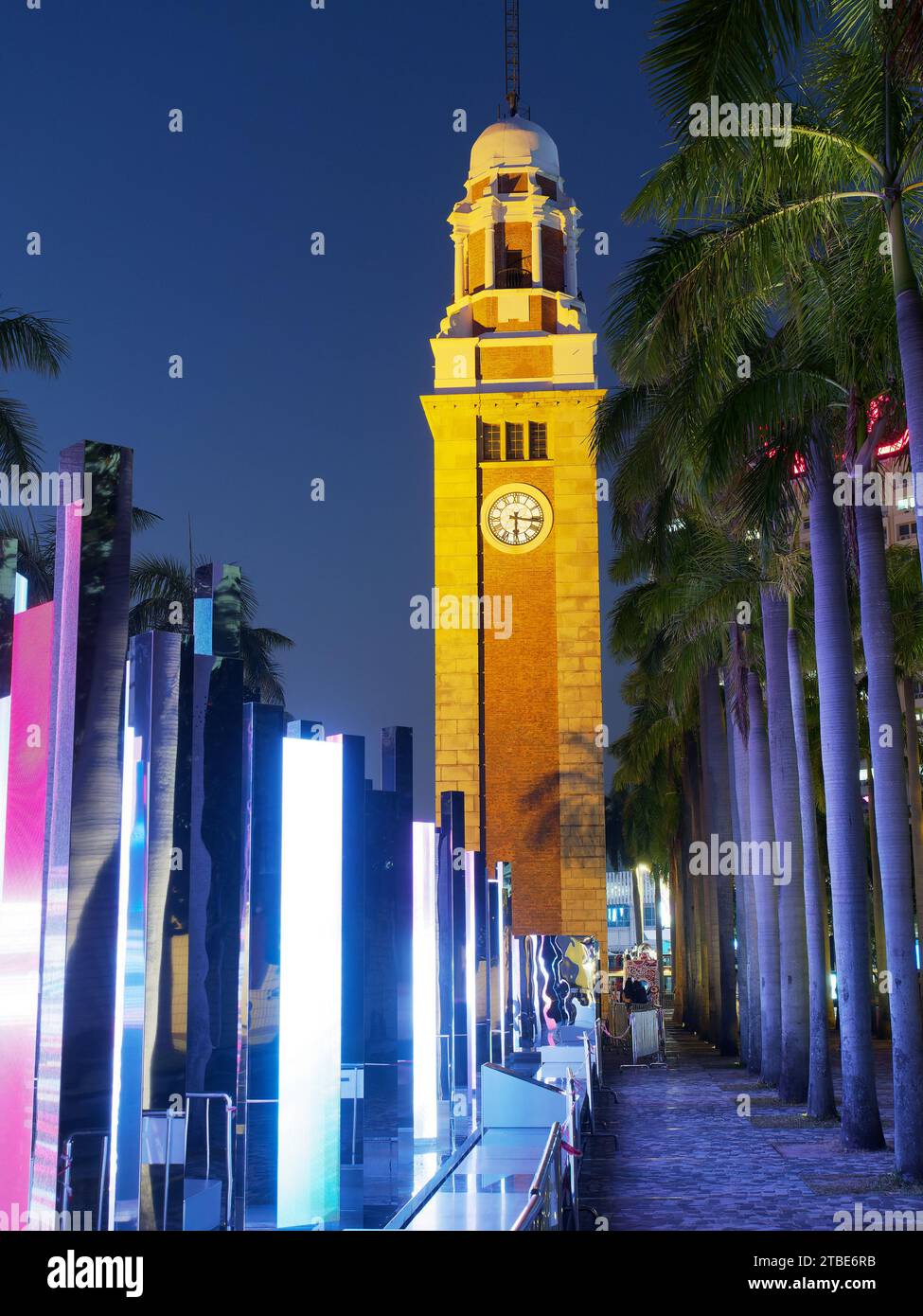 Regardant la vieille tour de l'horloge de la gare de Kowloon à Hong Kong la nuit avec un affichage lumineux coloré Banque D'Images
