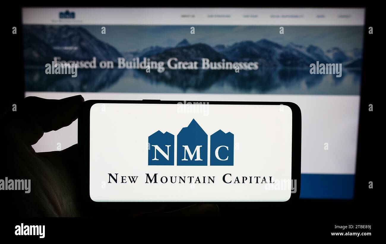 Personne détenant un téléphone portable avec le logo de la société d'investissement américaine New Mountain Capital (NMC) devant la page Web. Concentrez-vous sur l'affichage du téléphone. Banque D'Images