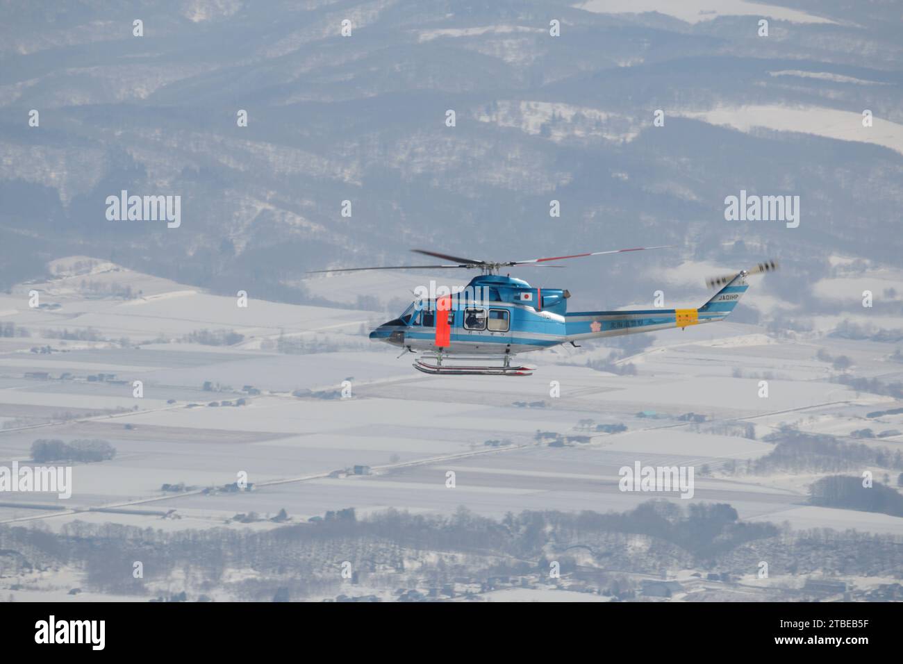 Hélicoptère de sauvetage en montagne survolant la station de ski de Niseko, Hokkaido, Japon Banque D'Images