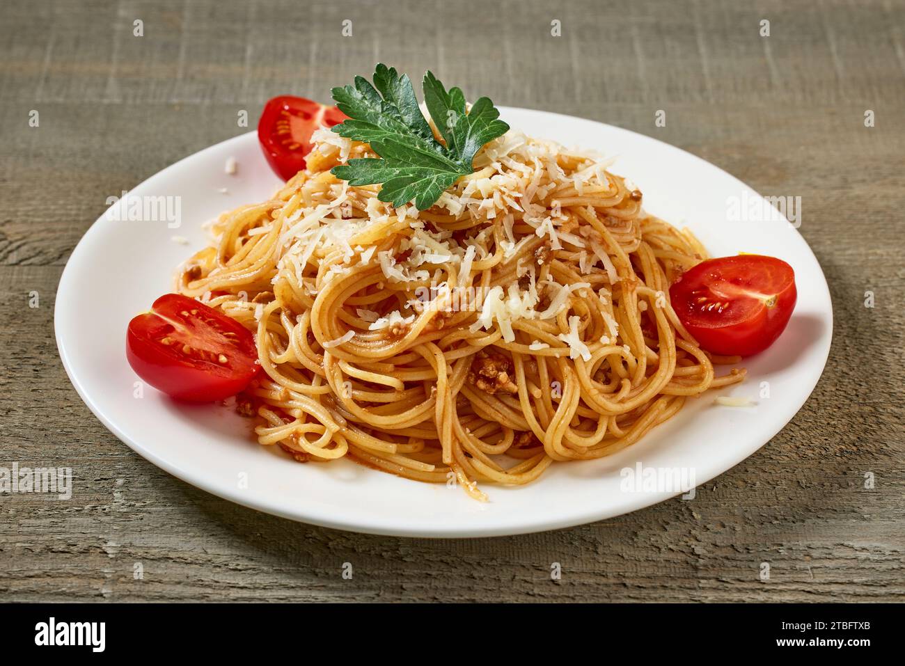 assiette de spaghetti avec sauce bolognaise et tomates sur table de cuisine en bois Banque D'Images