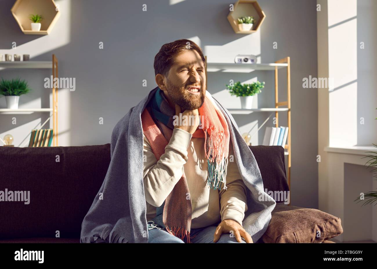 Un jeune homme malsain ressent une douleur intense et un mal de gorge, un malaise et une faiblesse. Banque D'Images