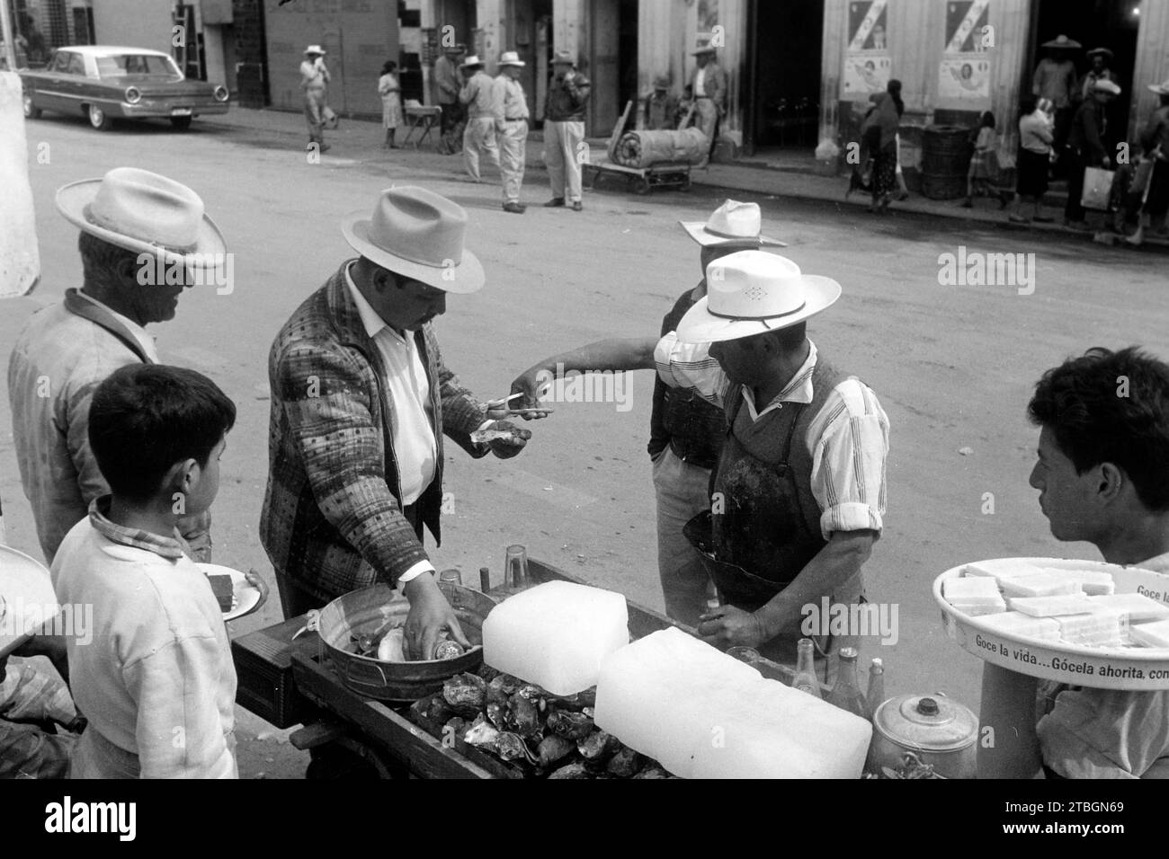 Ein Straßenverkäufer versorgt seine Kunden am Austernstand, Zacatecas 1964. Un vendeur de rue approvisionne ses clients dans un kiosque à huîtres, Zacatecas 1964. Banque D'Images