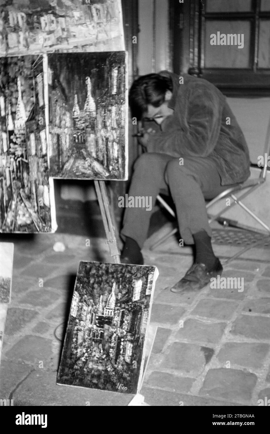 Ein Künstler versteckt sich vor der Kamera an der place du Tertre auf dem Montmartre, Paris 1962. Un artiste se cache de la caméra à la place du Tertre à Montmartre, Paris 1962. Banque D'Images